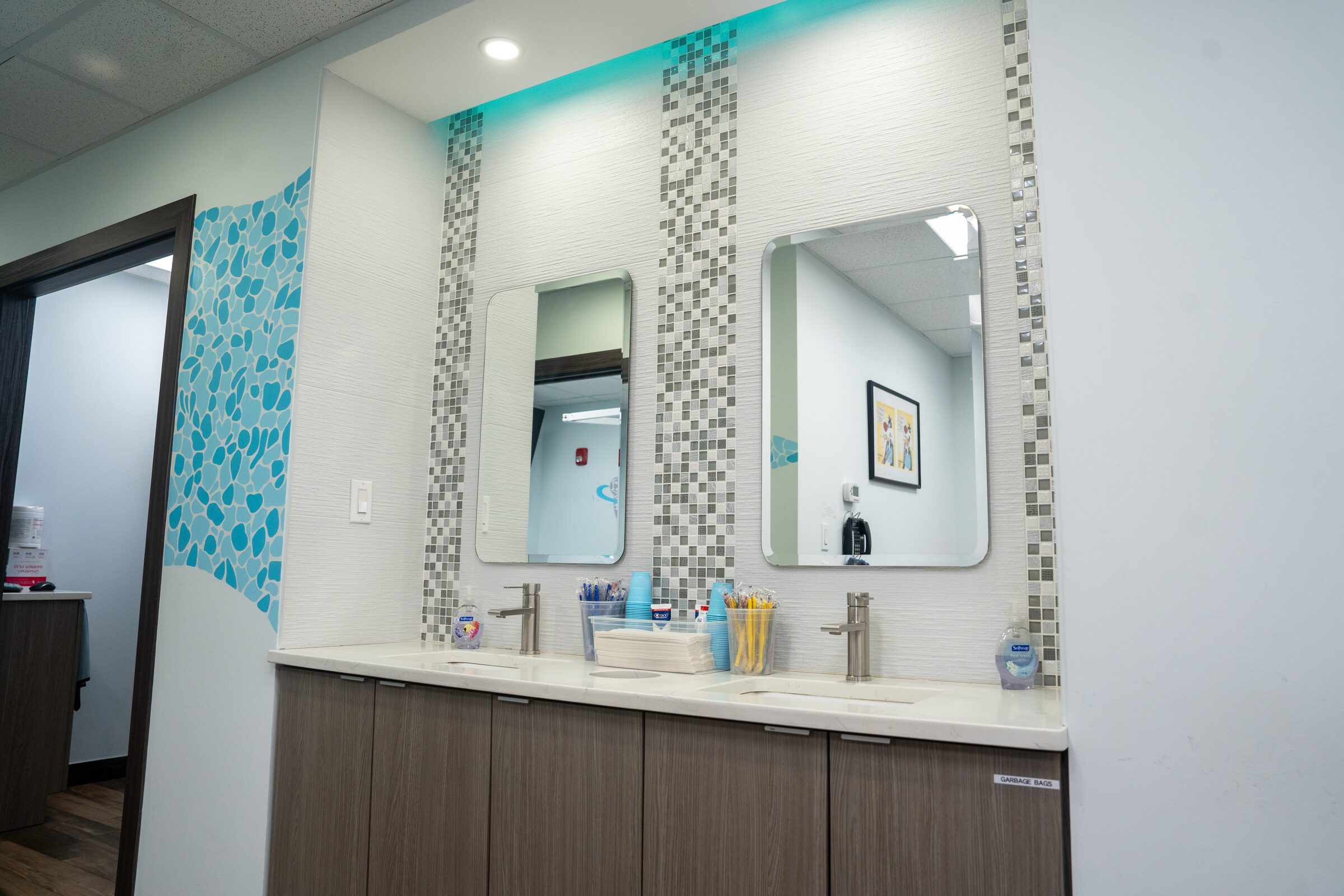 The brushing station: two sinks and mirrors, with cups and toothbrushes ready