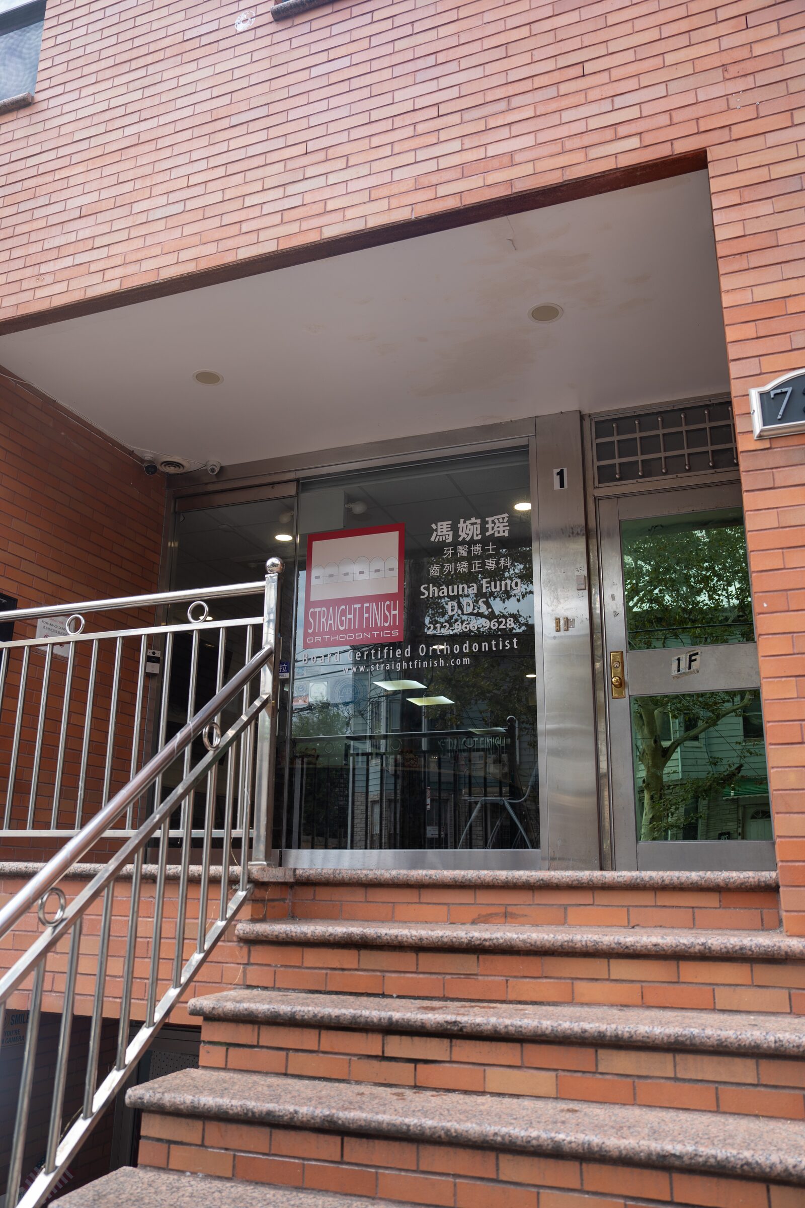 The Straight Finish Orthodontics entrance on 58th Street, Brooklyn: brick steps up to a glass door with the practice sign