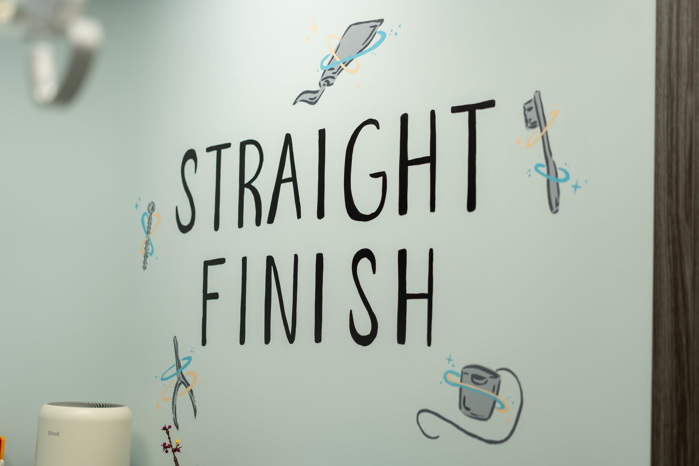 Hand-lettered Straight Finish wall art with drawings of orthodontic tools