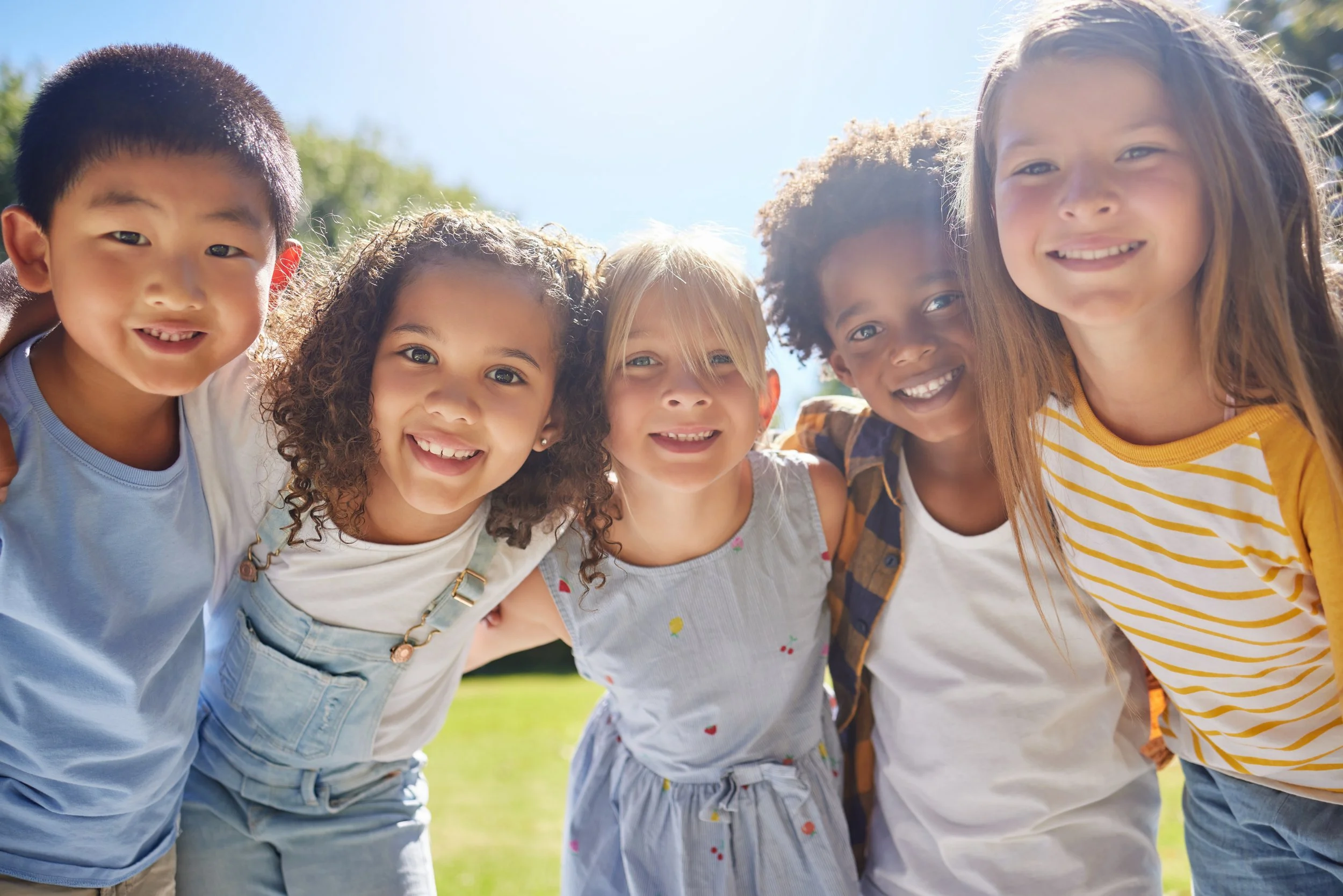 A group of smiling young children outdoors